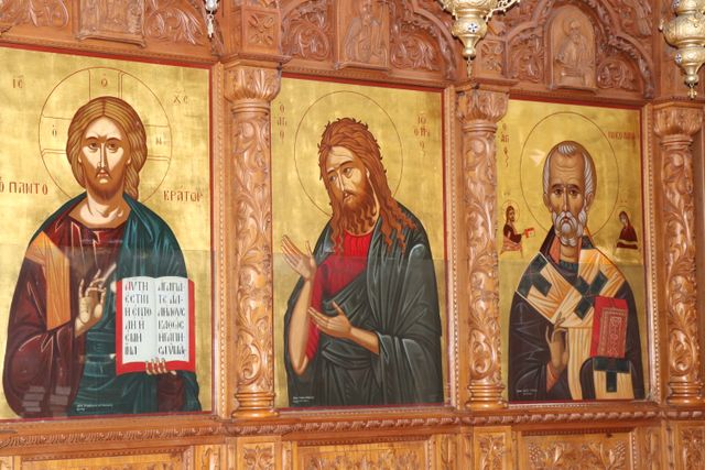 Trzy tradycyjne religijne ikony na drewnianej kościelnej ścianie